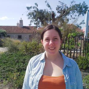 Jessica Middlemiss smiles at the camera in front of a house with a big garden